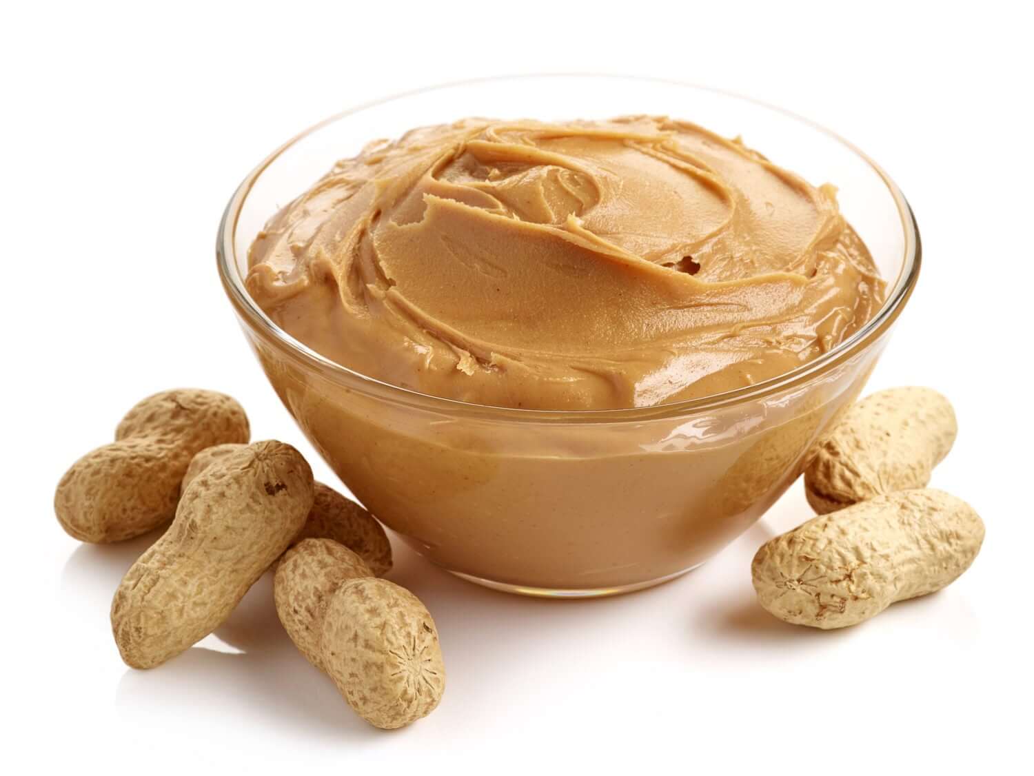 Glass bowl of peanut butter with peanuts